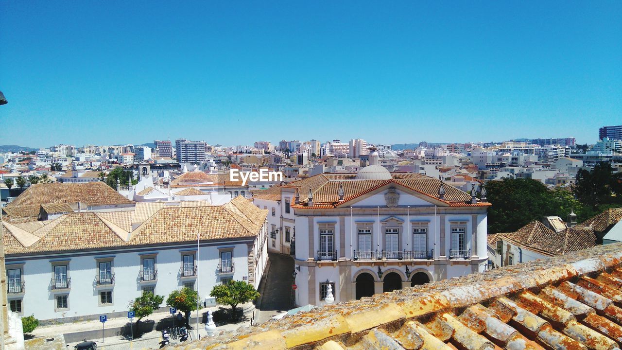 Residential district against clear blue sky