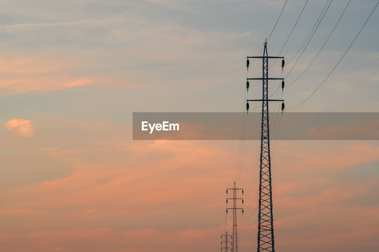 LOW ANGLE VIEW OF SILHOUETTE ELECTRICITY PYLON AGAINST ORANGE SKY