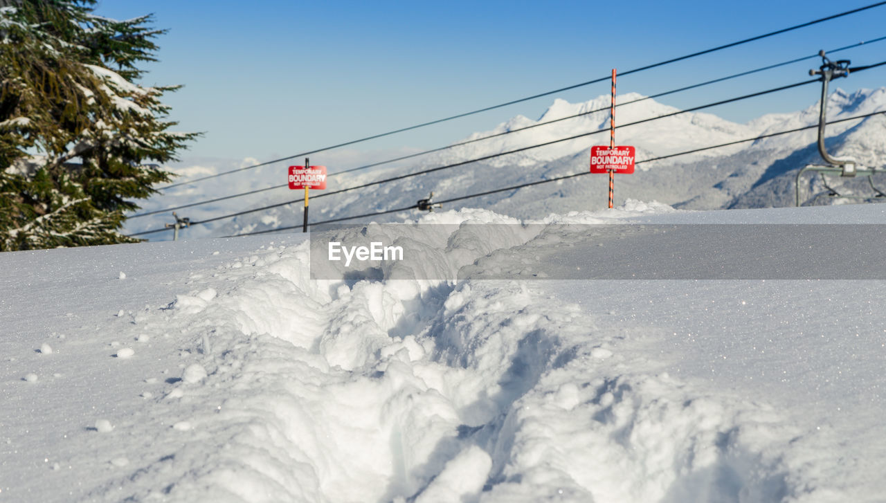 SKI LIFT OVER SNOW COVERED MOUNTAIN