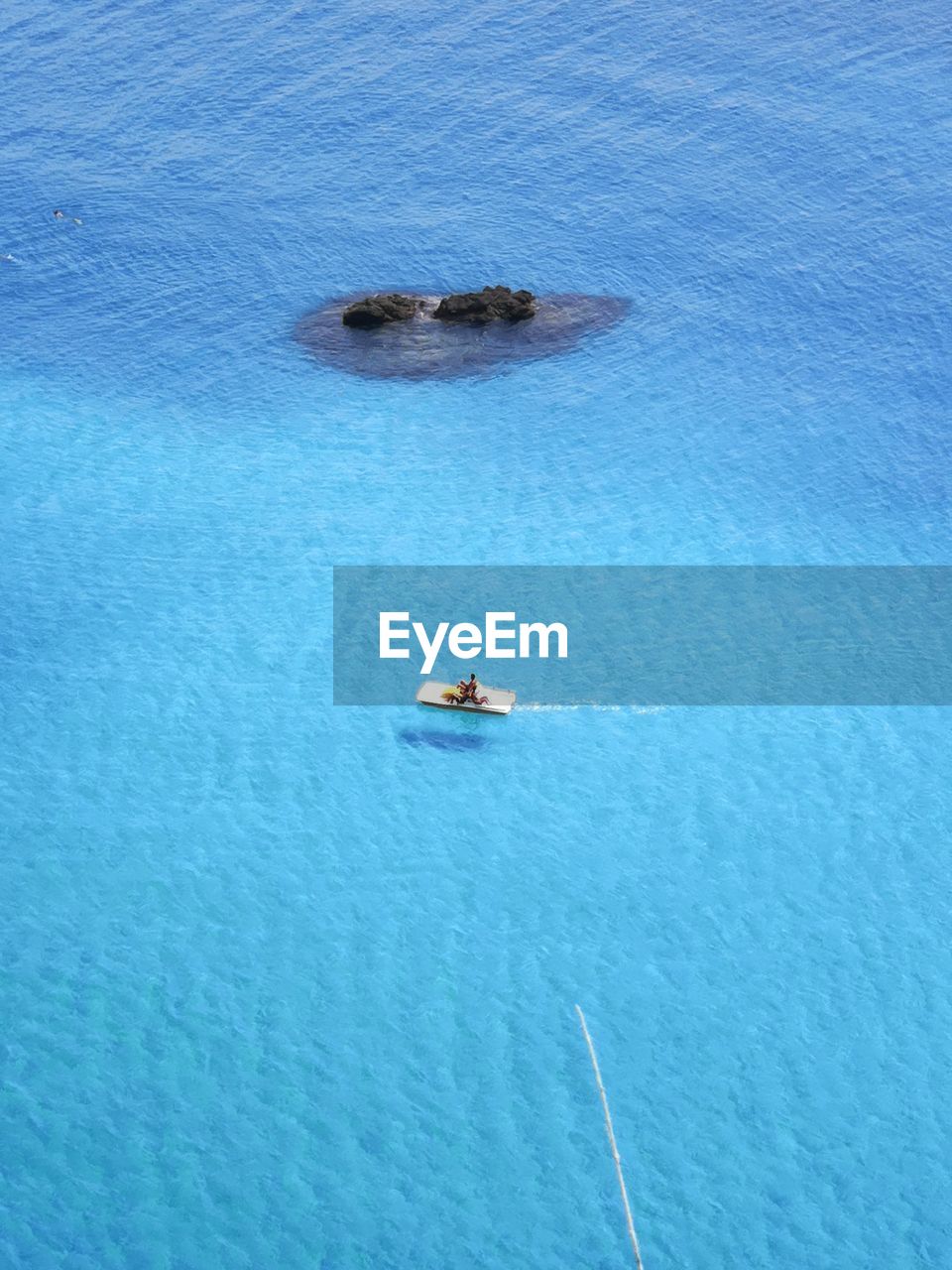 HIGH ANGLE VIEW OF SAILBOAT SAILING IN SEA