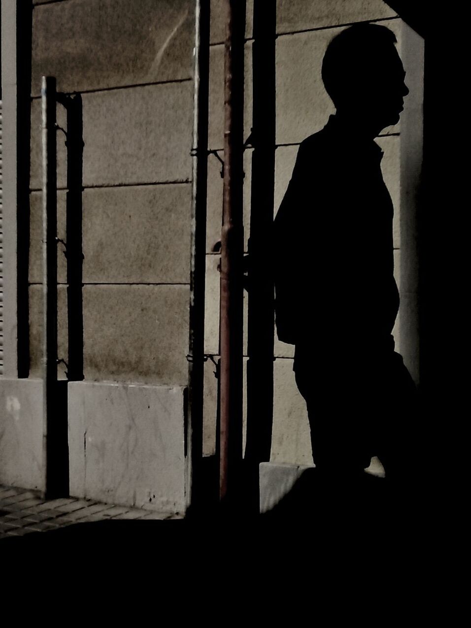 Man silhouette passing in front of concrete wall