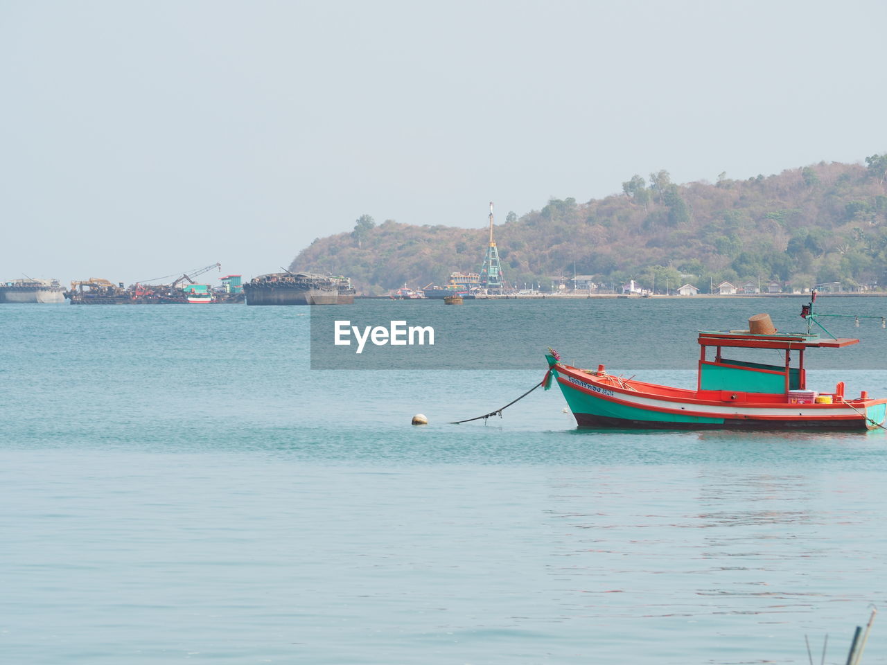 FISHING BOATS MOORED IN SEA AGAINST CLEAR SKY