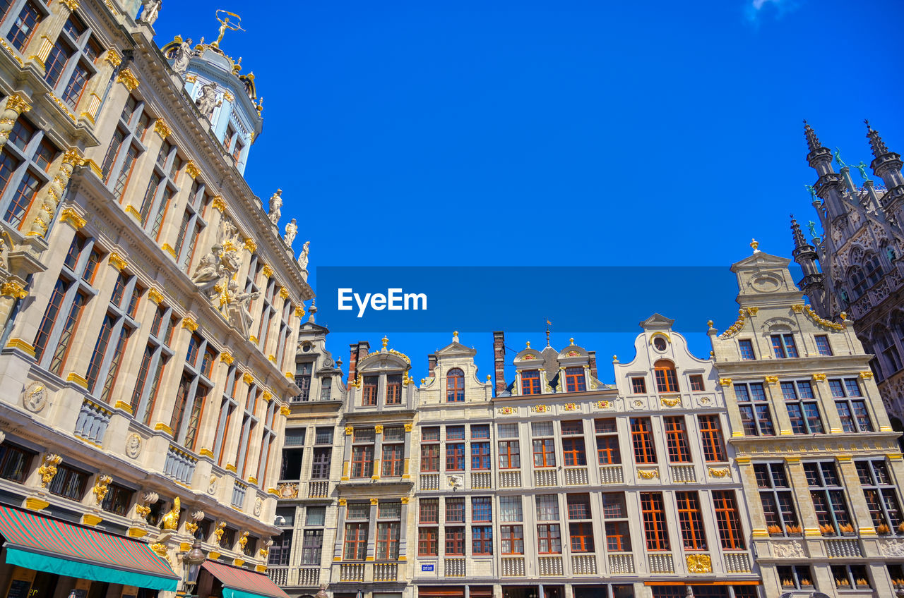 LOW ANGLE VIEW OF BUILDINGS IN CITY AGAINST BLUE SKY