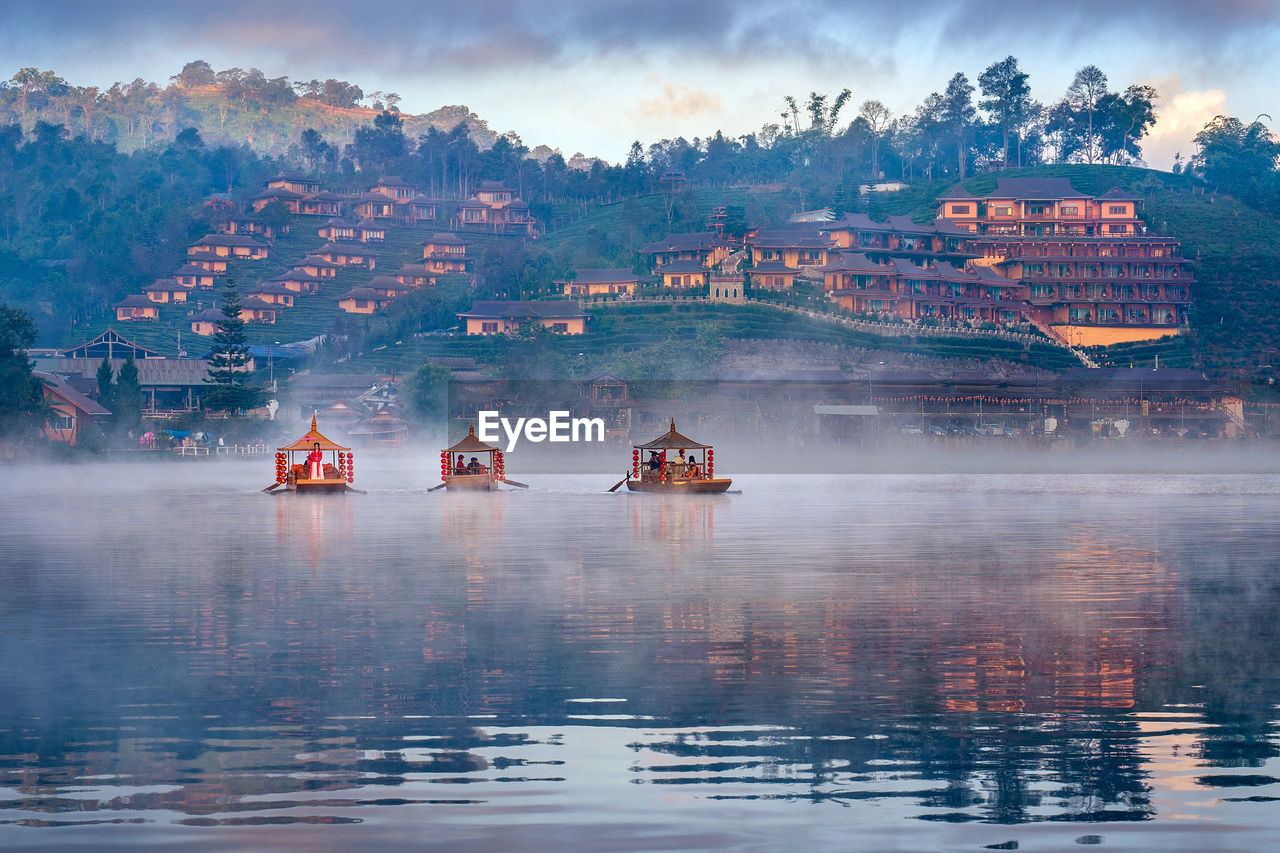 BOATS IN LAKE AGAINST BUILDINGS