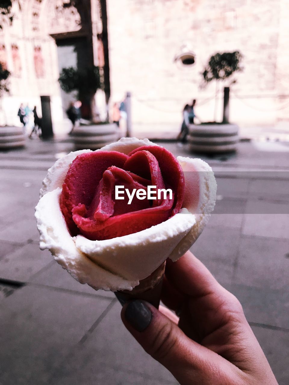 Close-up of woman hand holding ice cream on street in city