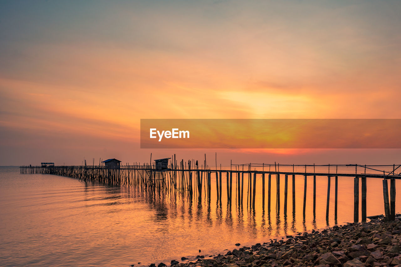 PIER ON SEA AGAINST ORANGE SKY