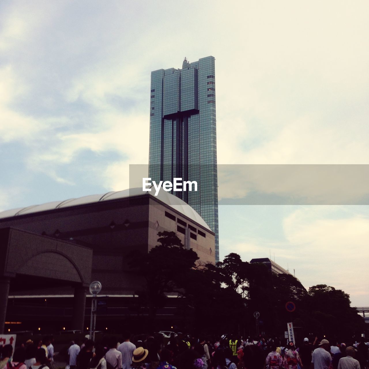 People looking at skyscraper in city