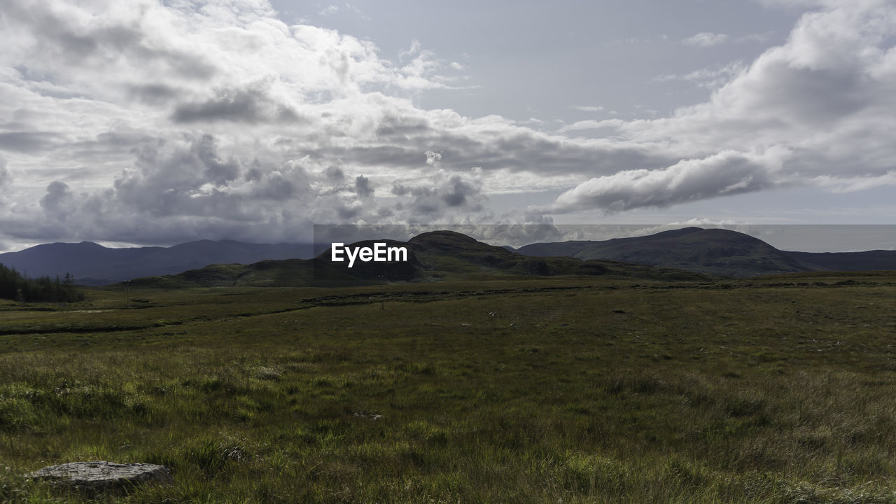 Scenic view of mountains against cloudy sky