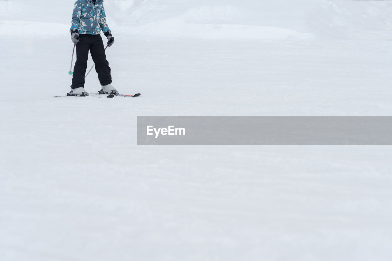 Low section of person snowboarding during winter