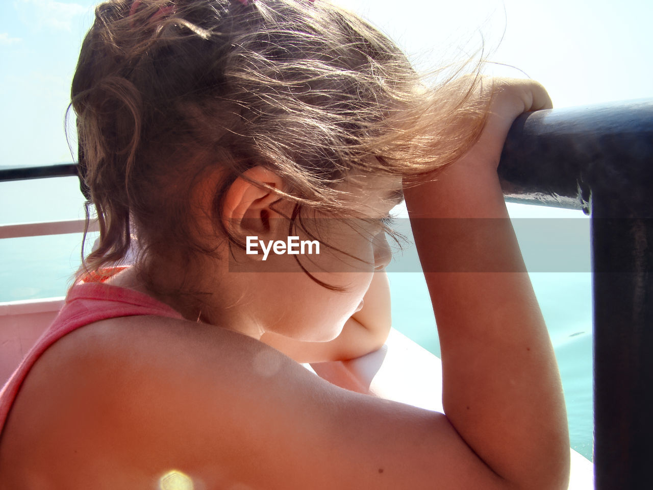 Close-up of girl looking away by railing