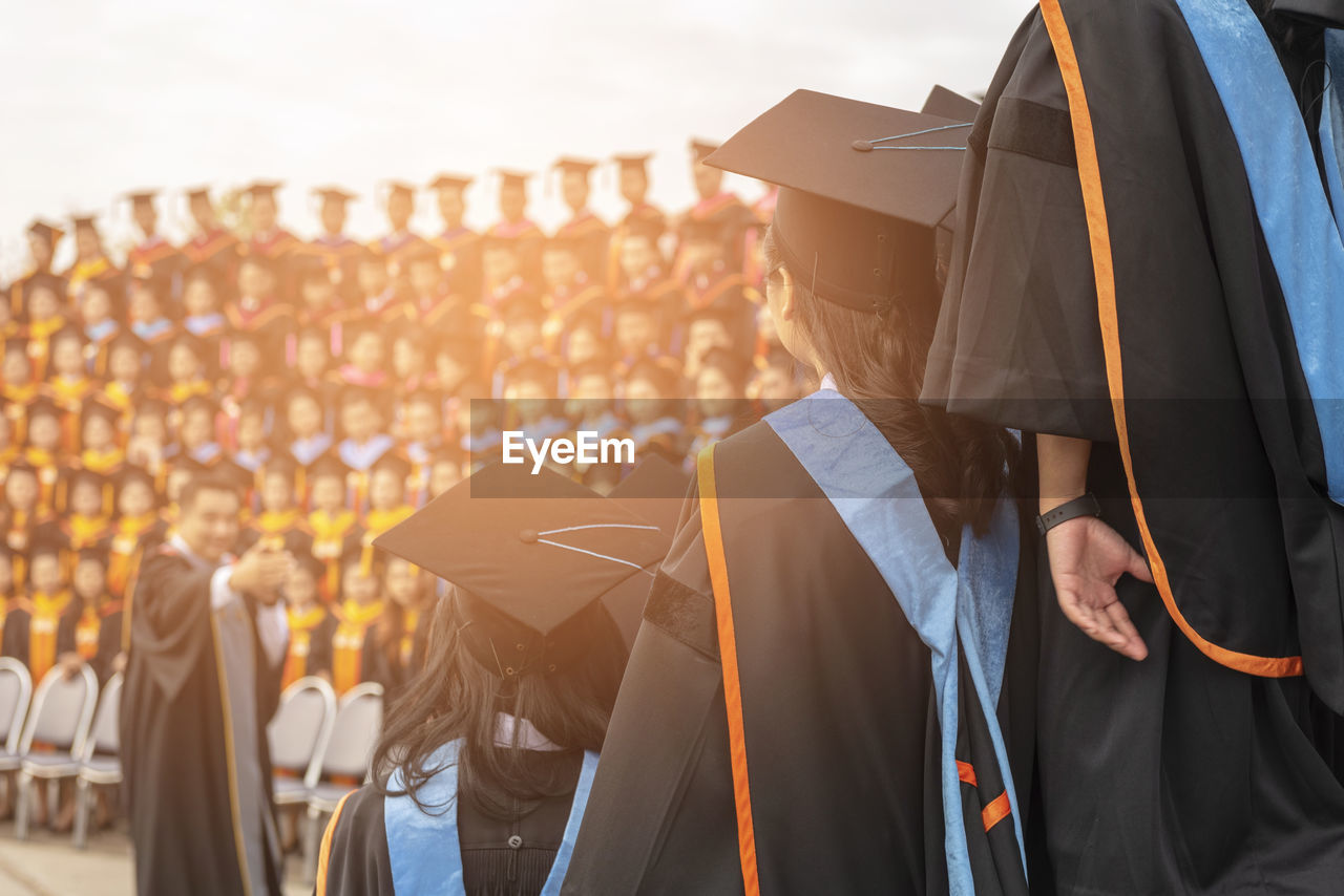 Women wearing mortarboard against sky