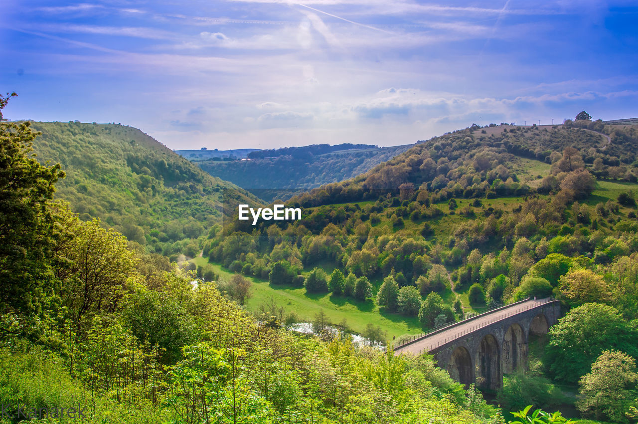 Scenic view of mountains against blue sky during sunny day