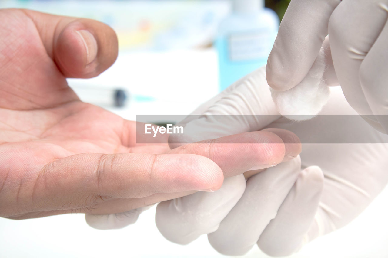 Close-up of doctor using cotton swab before injection