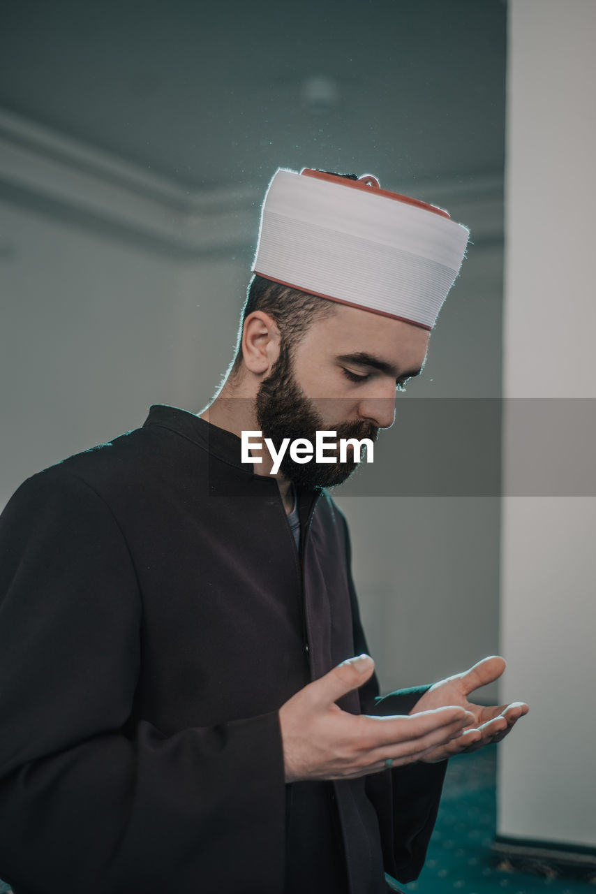 YOUNG MAN USING MOBILE PHONE IN LAPTOP