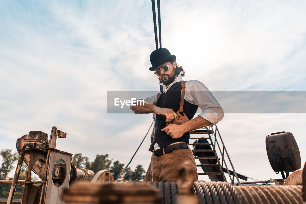 Low angle view of man photographing against sky