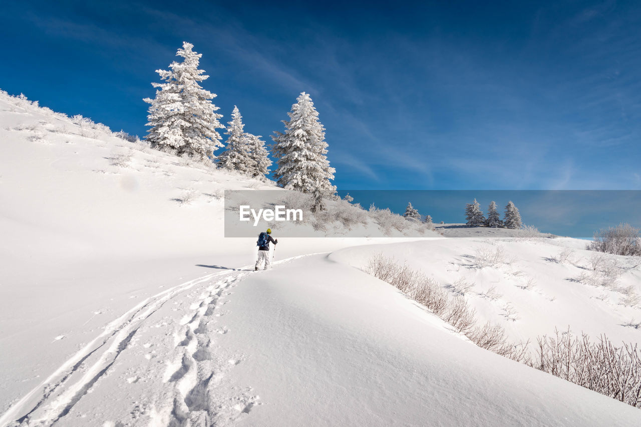 Person skiing on snowcapped mountain against sky