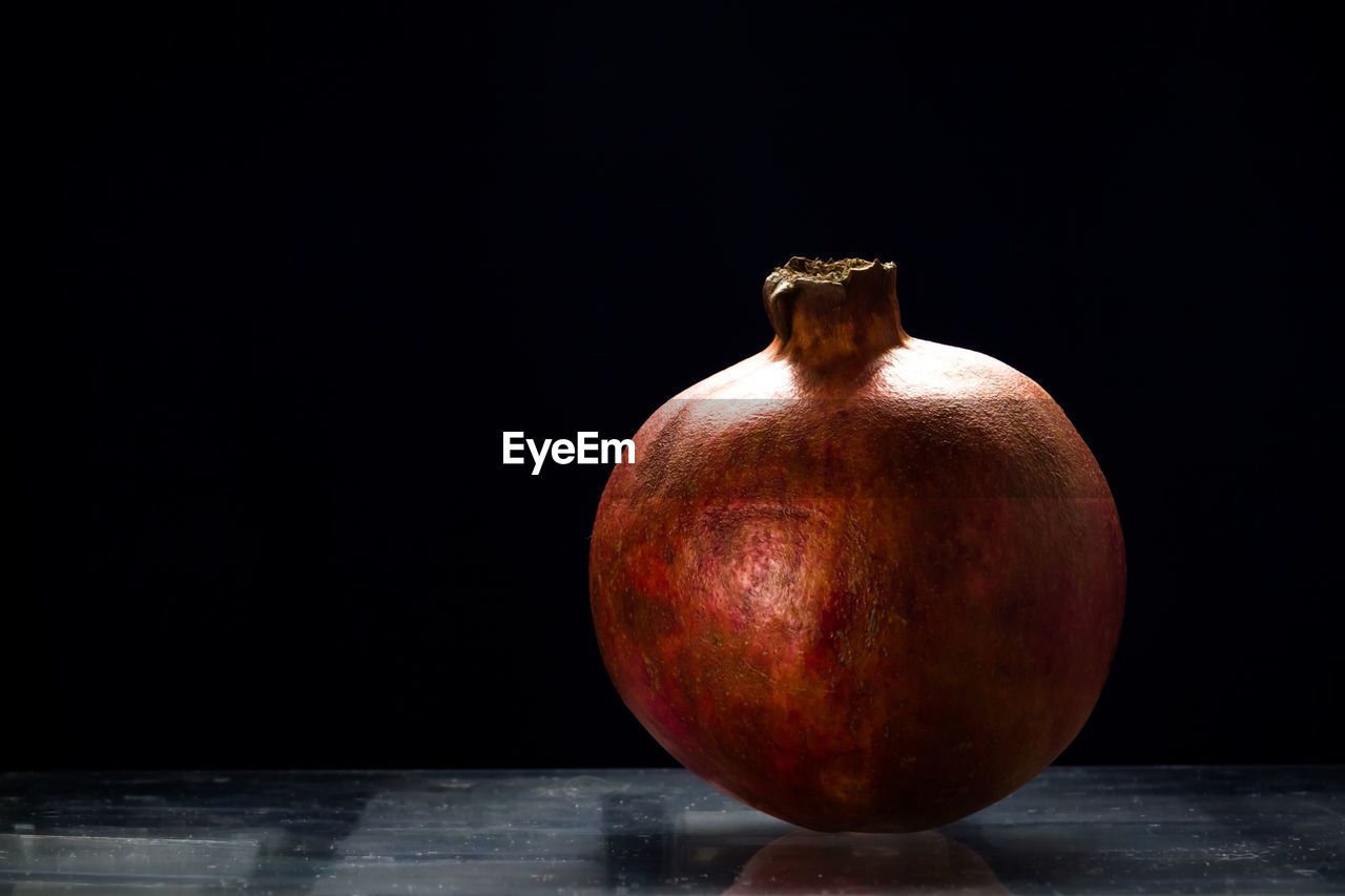 Ripe red pomegranate on the table, black background