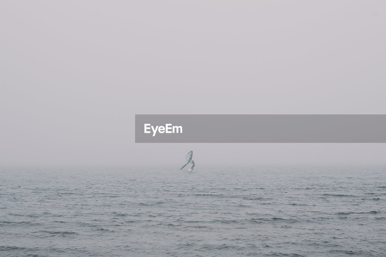 MAN ON SEA AGAINST CLEAR SKY