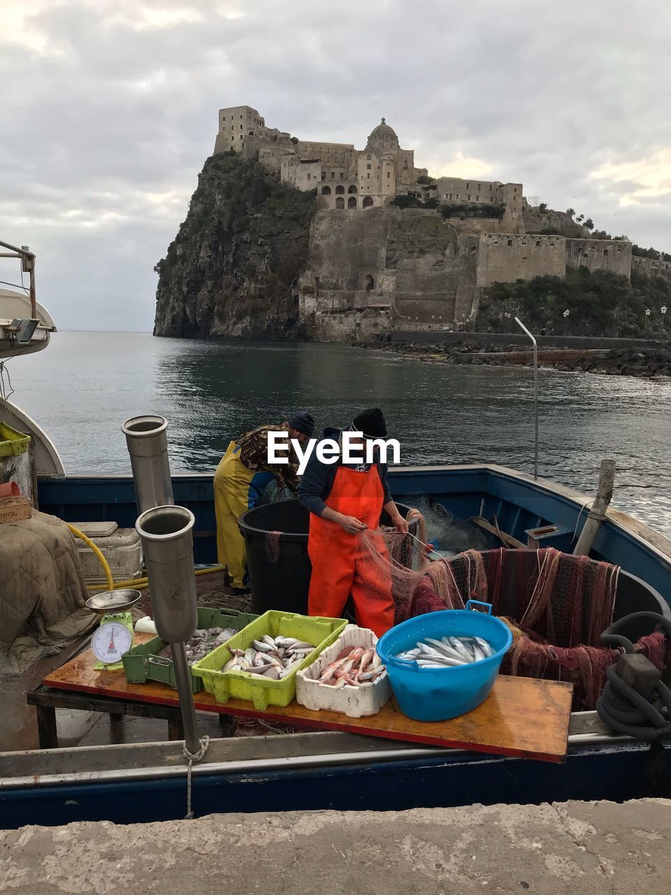 PEOPLE SITTING ON SHIP BY SEA