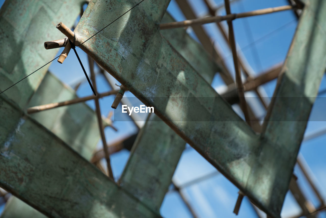 Low angle view of abandoned metallic structure against sky