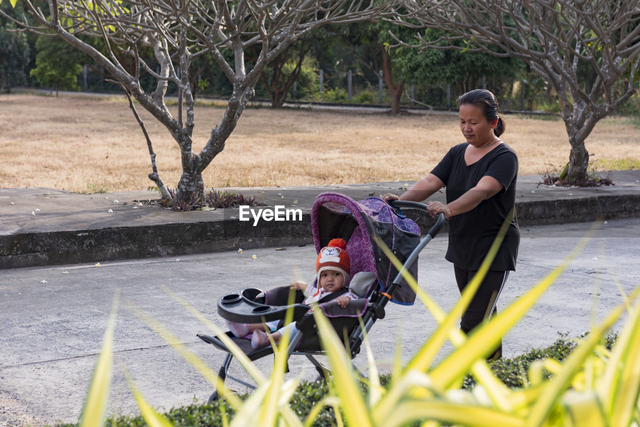 Happy little baby learning to walk with mother help at home.