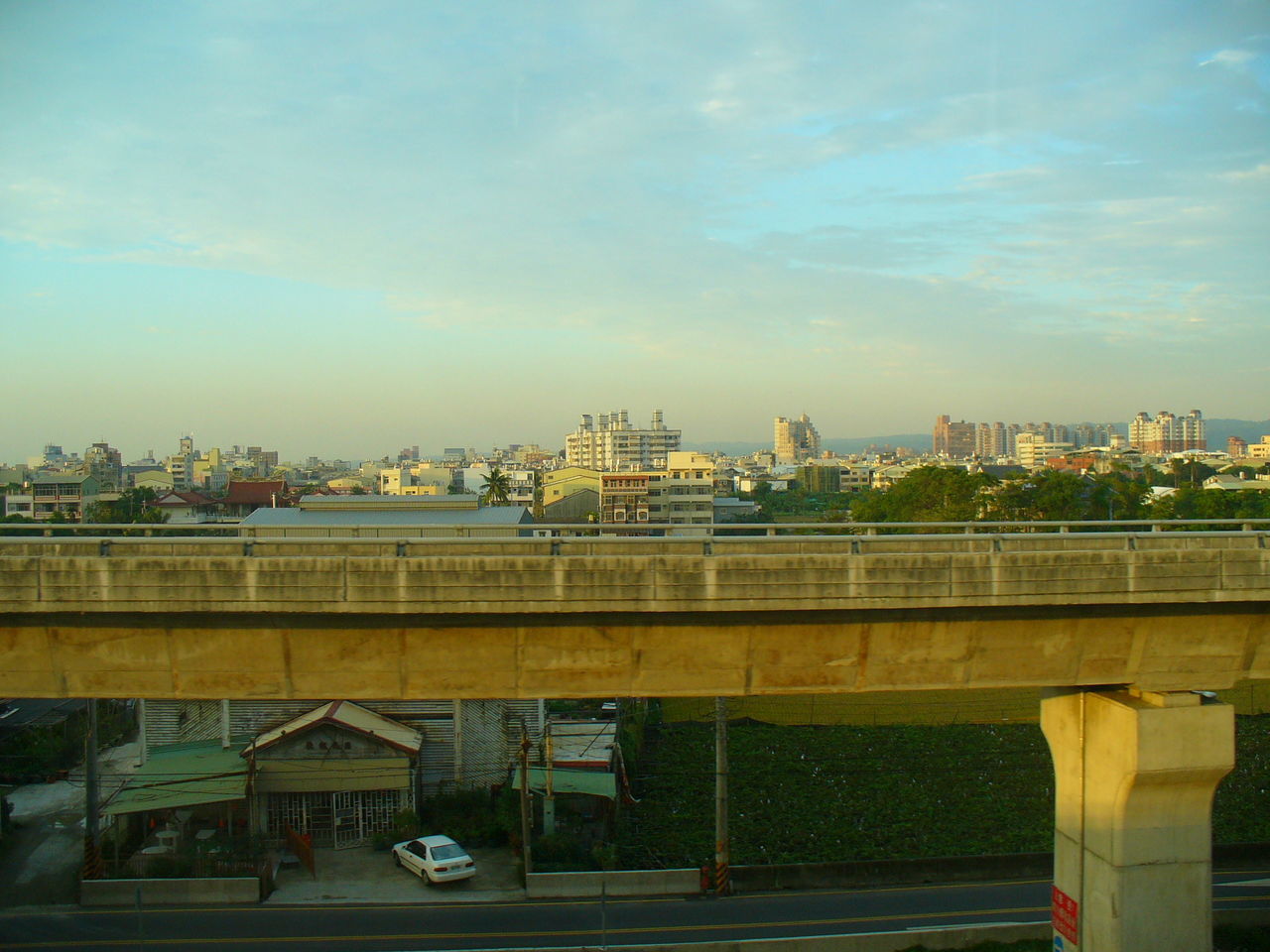 View of cityscape against cloudy sky