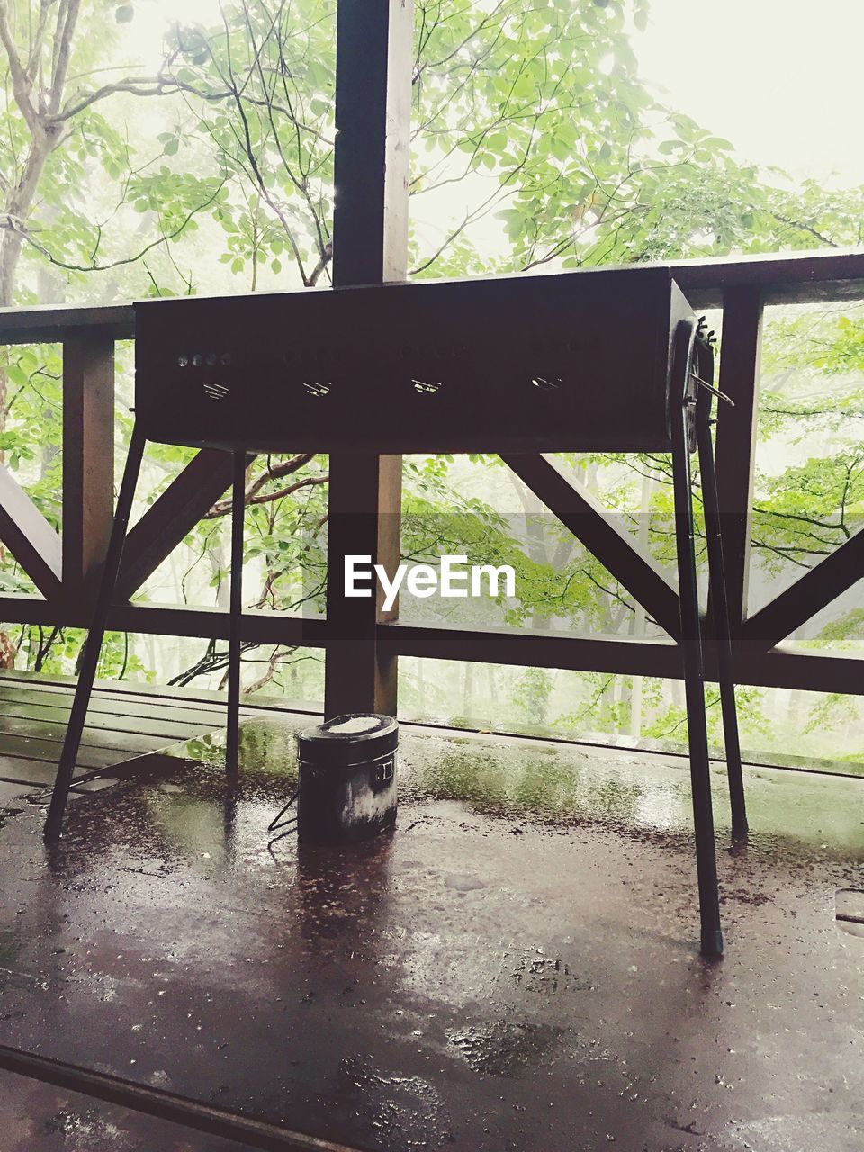 Barbecue grill by fence during rainy season