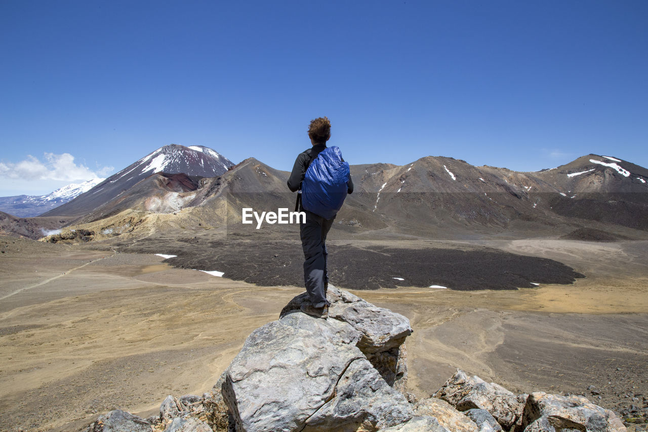 Male hiker looking at scenic landscape of a lava field and a volcano