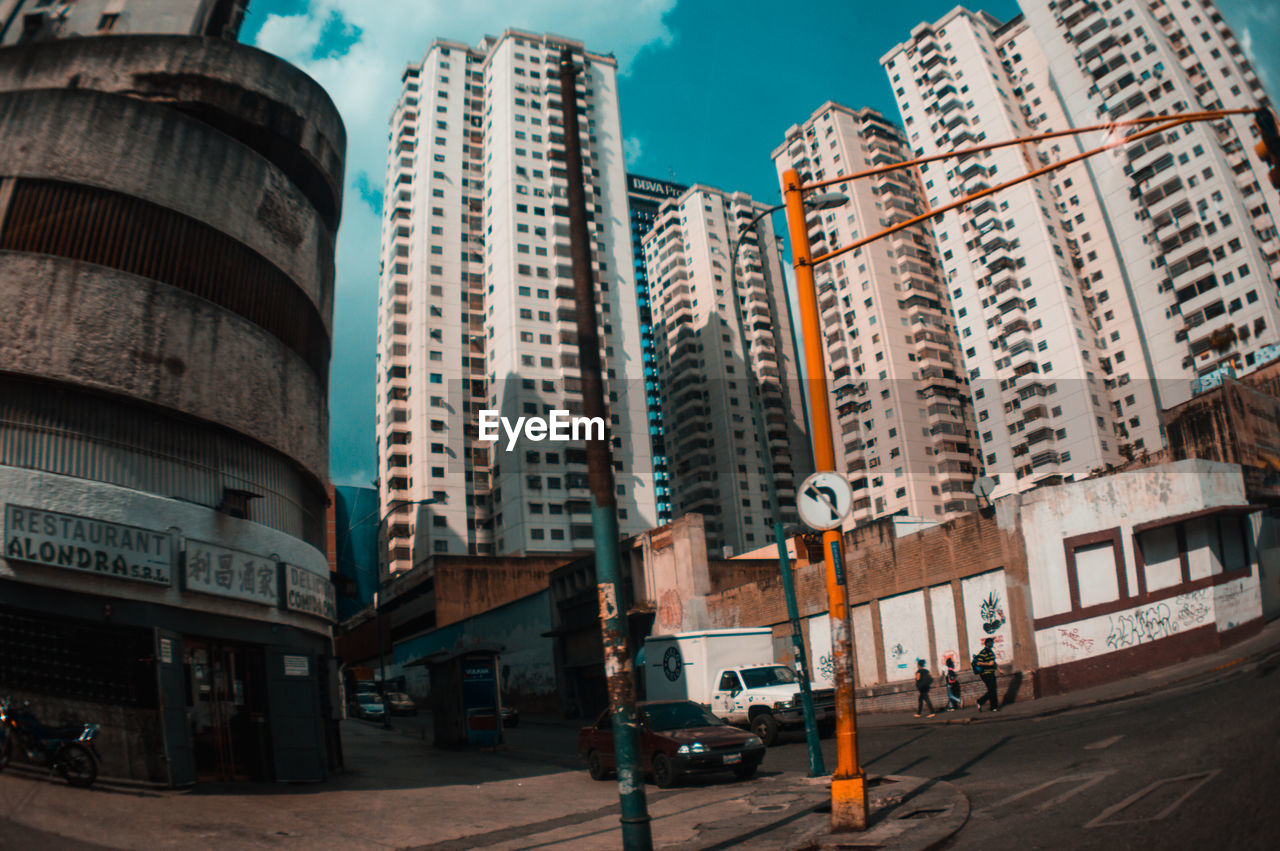 CARS ON ROAD BY BUILDINGS IN CITY