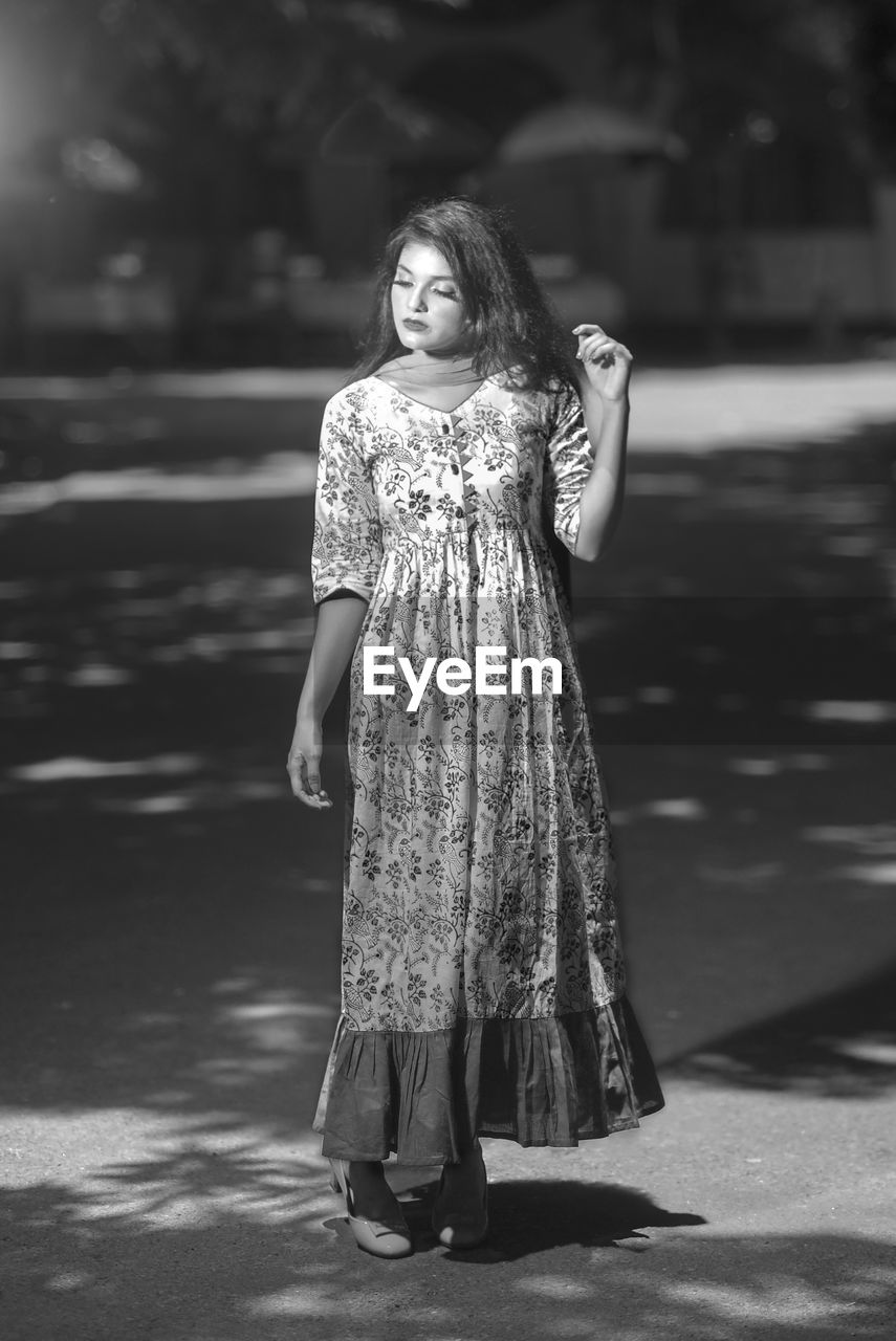 Young woman standing on footpath