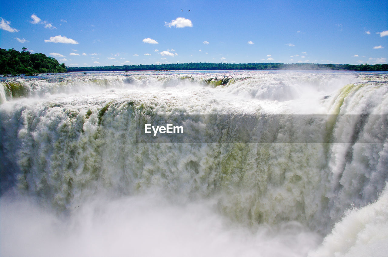 Scenic view of waterfall against sky