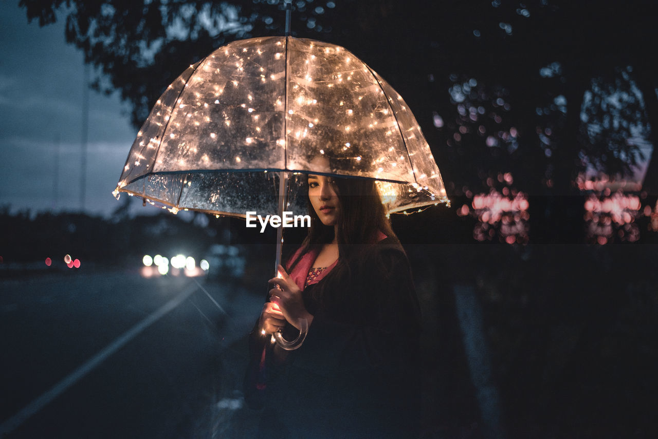 WOMAN STANDING WITH UMBRELLA