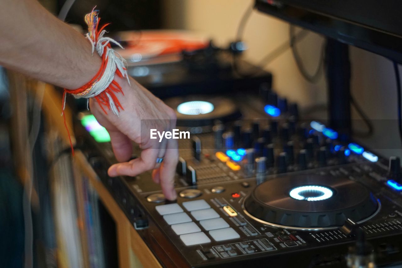 Cropped hand of man mixing music at recording studio
