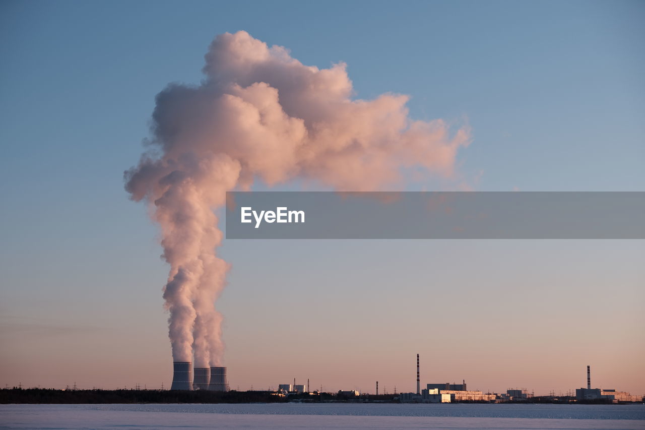 SMOKE EMITTING FROM CHIMNEY AGAINST SKY AT SUNSET