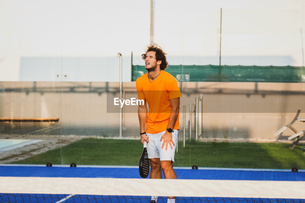 Tennis player standing on tennis court