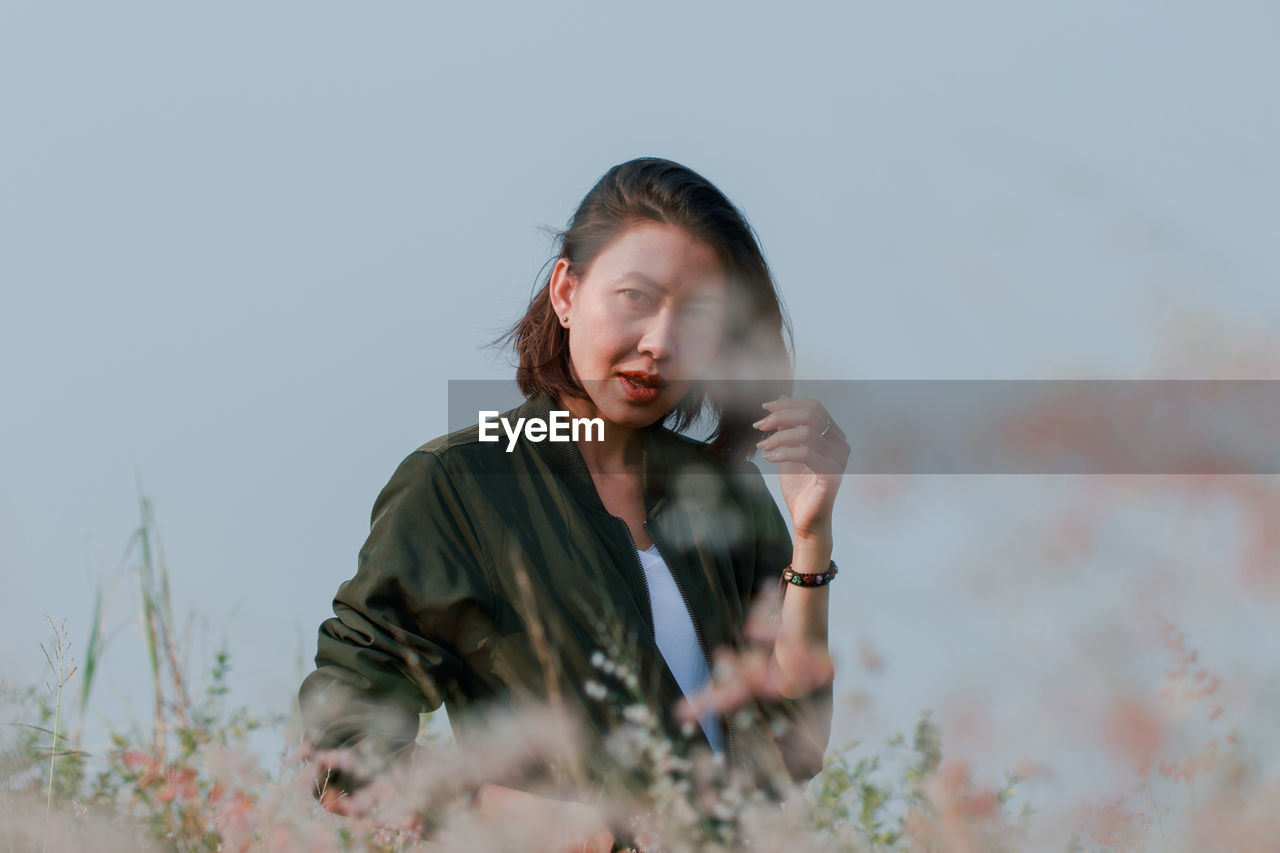 Portrait of woman on field against sky