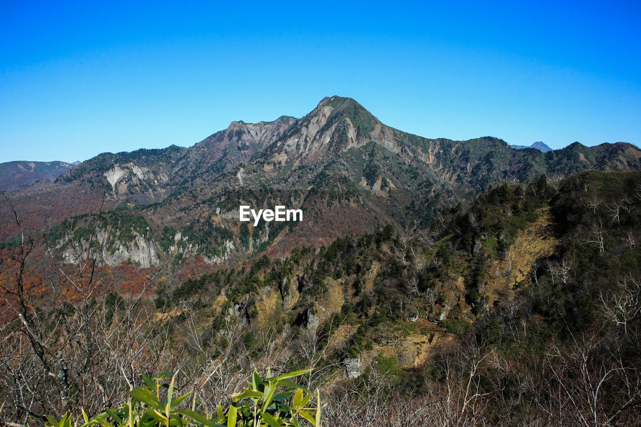 Scenic view of mountains against clear blue sky