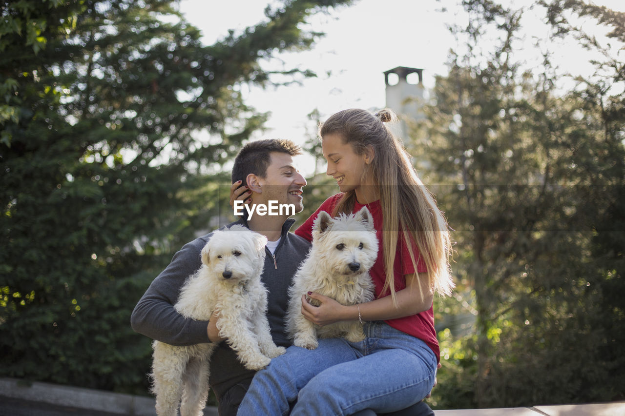 Young couple with dogs relaxing at park