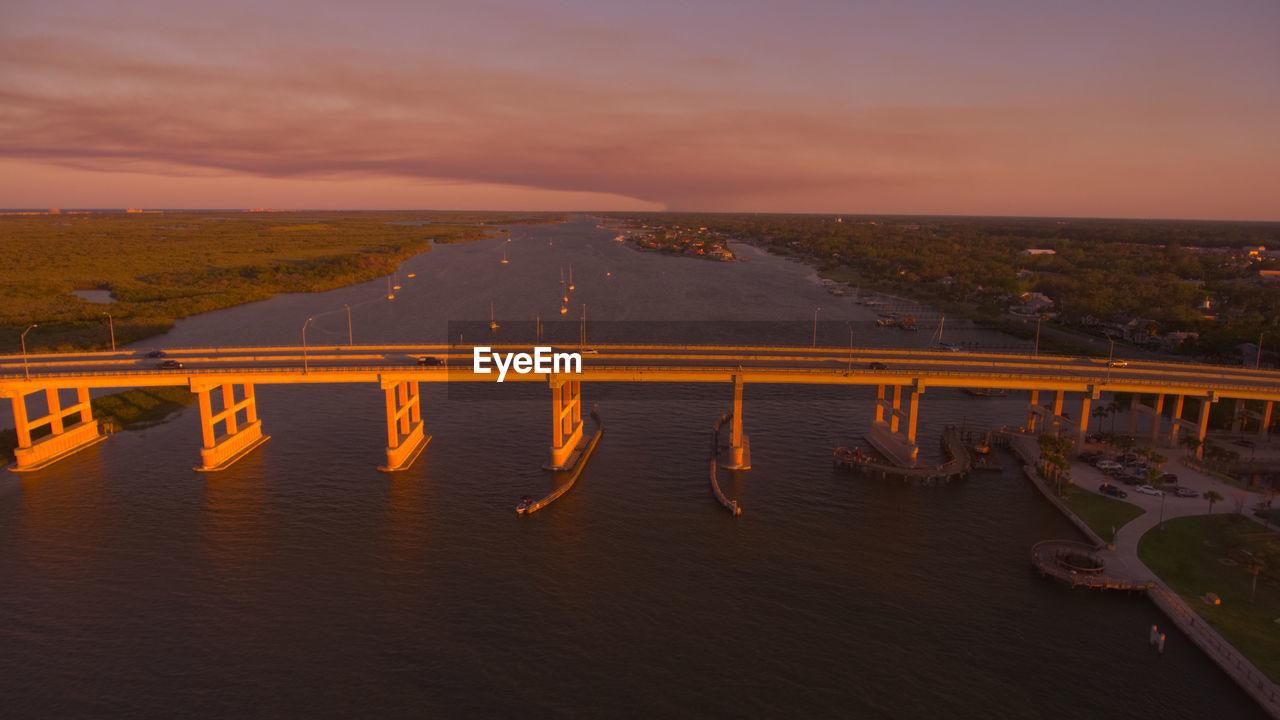 Scenic view of bridge over river against sky during sunset