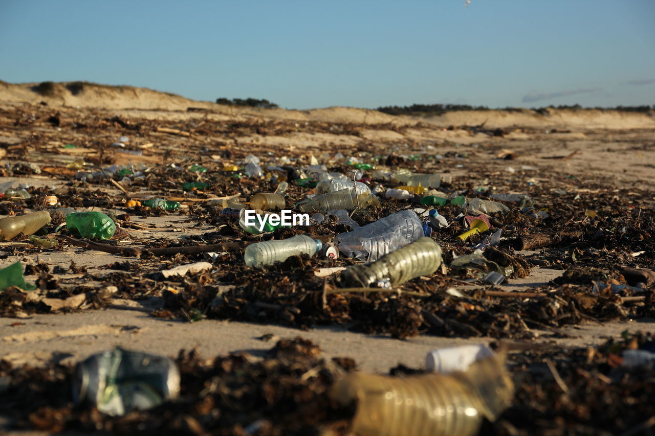 Surface level of garbage on beach against sky