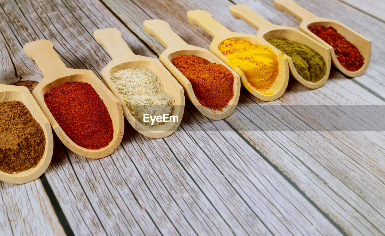 High angle view of various spices in spoons on table