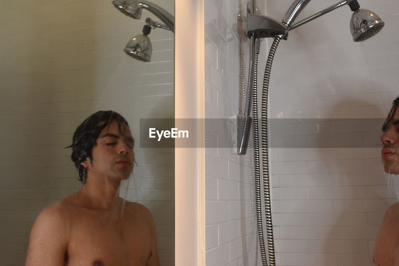 Young man looking on the shower