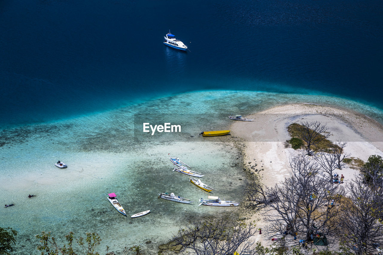 High angle view of a remote beach and boats in pacific ocean, komodo national park indonesia