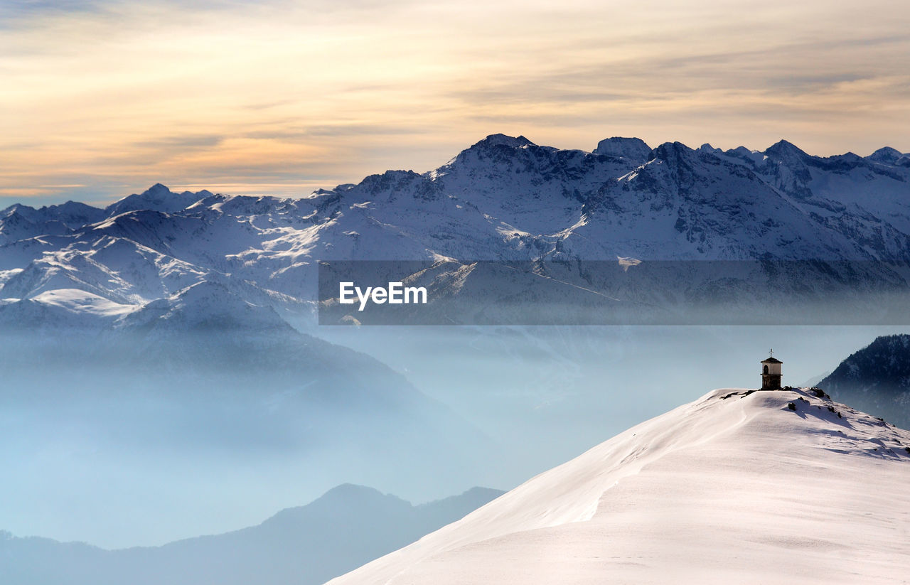 Scenic view of snowcapped mountains against sky during sunset