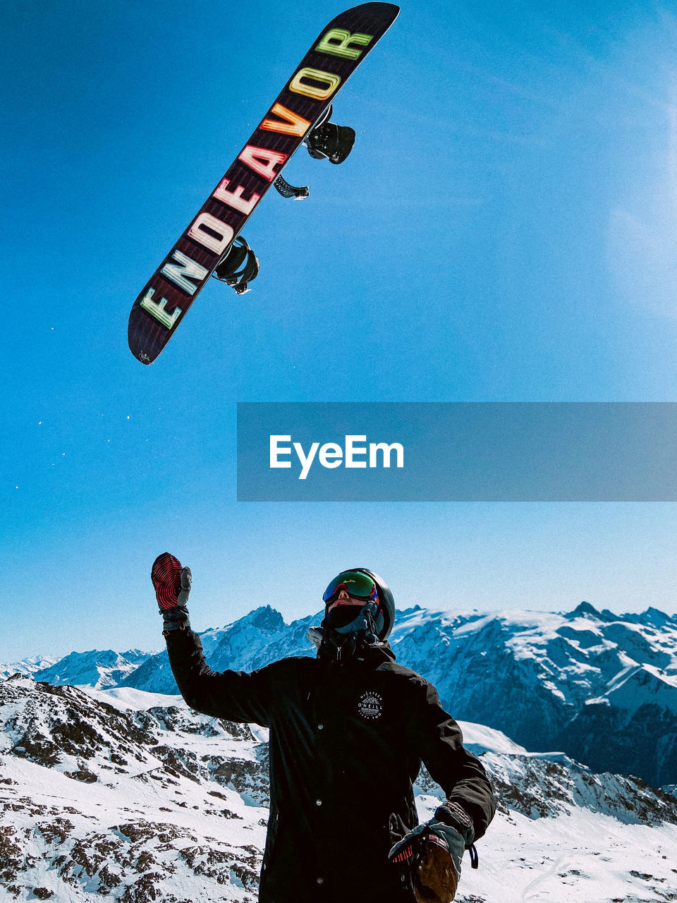 LOW SECTION OF MAN ON SNOWCAPPED MOUNTAIN AGAINST SKY