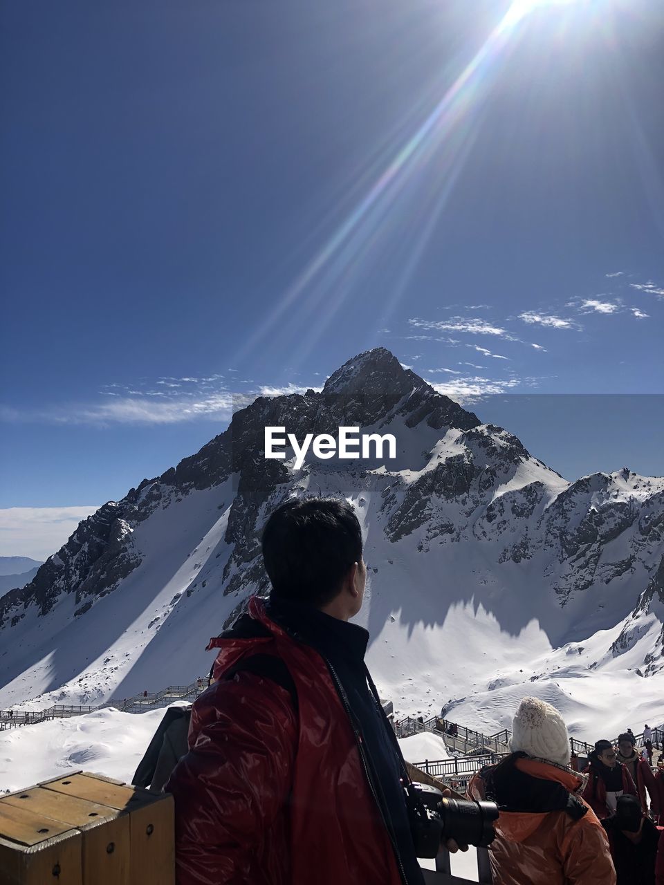 WOMAN ON SNOWCAPPED MOUNTAIN AGAINST SKY