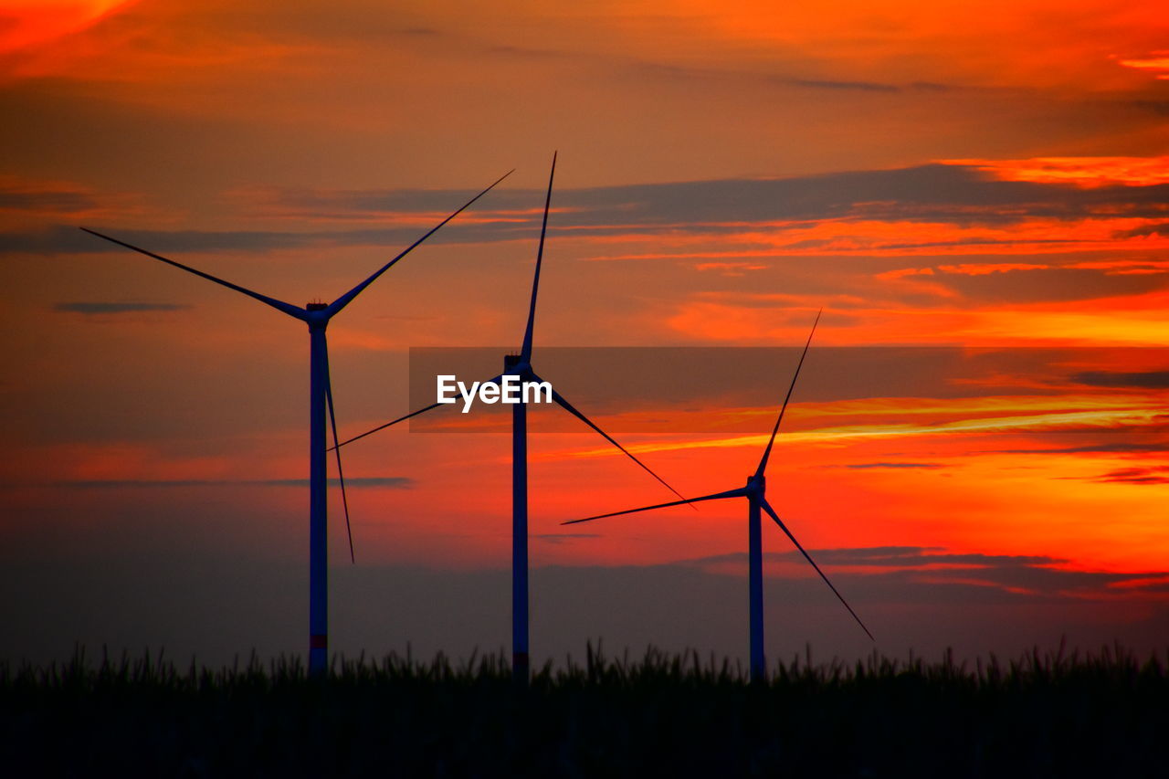 Scenic view of sunset sky and windmills 