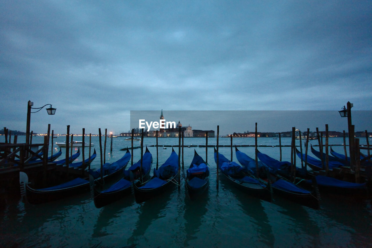 Gondolas on grand canal in city at dusk