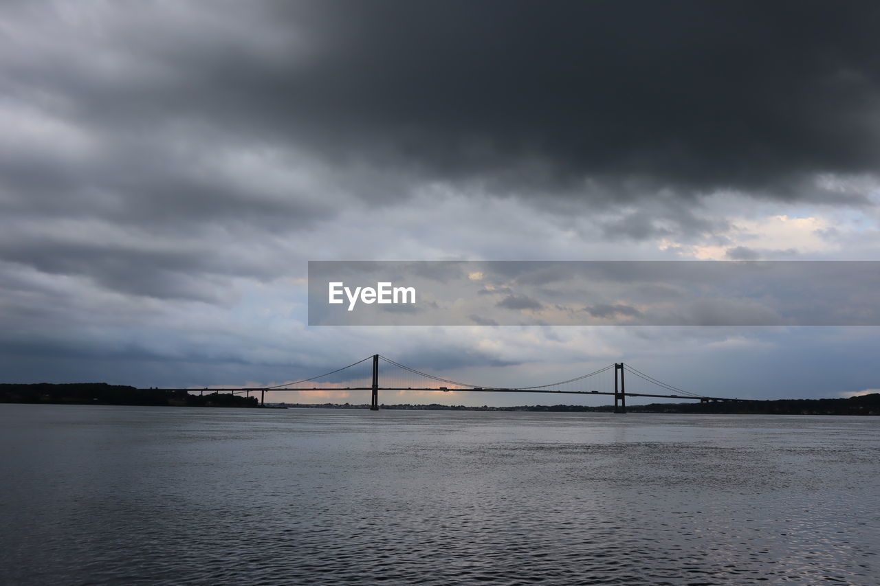 BRIDGE OVER SEA AGAINST CLOUDY SKY