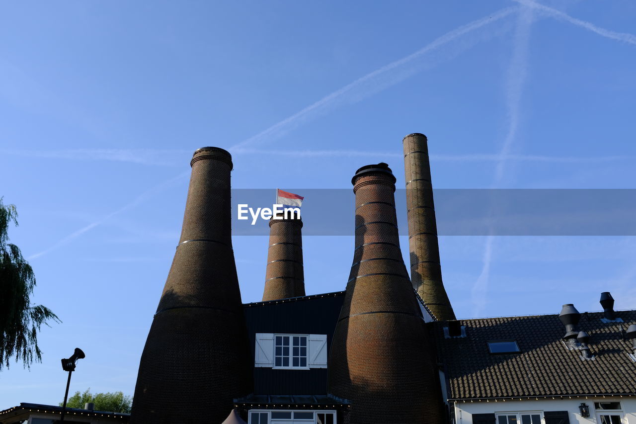 Low angle view of smoke stack against sky